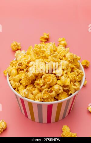 Karamell von Pop-Icons in bunten Cups auf rosa Hintergrund Stockfoto