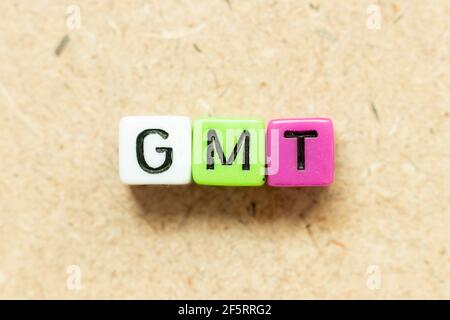 Farbe Alphabet Buchstabenblock in Wort GMT (Abkürzung für Greenwich Mean Time) auf Holzhintergrund Stockfoto