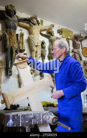 26. März 2021, Sachsen, Neudörfel: Nikolaus Dürlich arbeitet in seiner Werkstatt an einem Holzkreuz. Der sorbische Holzbildhauer fertigt und restauriert in dritter Generation Kreuze und religiöse Figuren. Foto: Sebastian Kahnert/dpa-Zentralbild/dpa Stockfoto