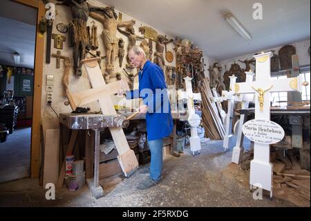 26. März 2021, Sachsen, Neudörfel: Nikolaus Dürlich arbeitet in seiner Werkstatt an einem Holzkreuz. Der sorbische Holzbildhauer fertigt und restauriert in dritter Generation Kreuze und religiöse Figuren. Foto: Sebastian Kahnert/dpa-Zentralbild/dpa Stockfoto