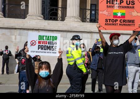 Demonstranten hielten Plakate, die ihre Meinung während einer friedlichen Demonstration zum Ausdruck brachten.Myanmar Anti-Militärputsch Demonstranten versammelten sich am Trafalgar Square, während Dutzende weitere im Land getötet werden. Polizei und Militärsoldaten aus Myanmar (Tatmadow) griffen Demonstranten am Samstag in Myanmar mit Gummigeschossen, lebender Munition, Tränengas und Betäubungsbomben als Reaktion auf antimilitärische Putschprotestierende an, töteten mehr als 90 Menschen und verletzten viele andere. Mindestens 300 Menschen sind seit dem Putsch vom 1. Februar in Myanmar getötet worden, sagte ein Menschenrechtsbeamter der Vereinten Nationen. Das Militär von Myanmar hat den Staatsanwalt festgenommen Stockfoto