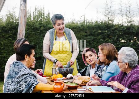 lateinische Großmutter und Enkelin, Tochter, die zu Hause mexikanisches Essen kocht, drei Generationen von Frauen in Mexiko Stockfoto