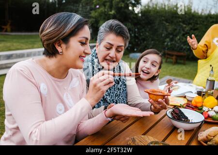 lateinische Großmutter und Enkelin, Tochter, die zu Hause mexikanisches Essen kocht, drei Generationen von Frauen in Mexiko Stockfoto