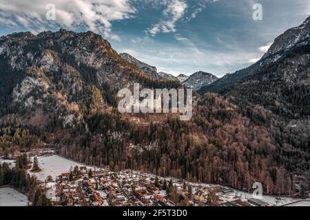 Luftdrohnenaufnahme des malerischen Schlosses Neuschwanstein auf einem verschneiten Hügel Im Winter Sonnenlicht in Deutschland Stockfoto