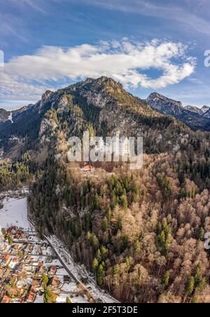 Luftdrohnenaufnahme des malerischen Schlosses Neuschwanstein auf einem verschneiten Hügel Im Winter Sonnenlicht in Deutschland Stockfoto