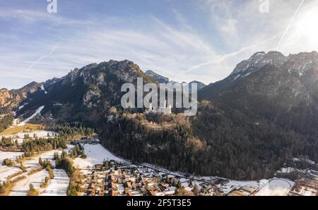 Luftdrohnenaufnahme des malerischen Schlosses Neuschwanstein auf einem verschneiten Hügel Im Winter Sonnenlicht in Deutschland Stockfoto