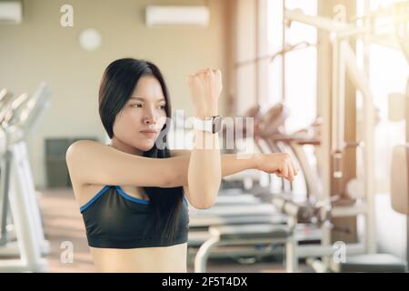 Junge asiatische gesunde Frau tun Arm Muskel Stretching, wärmen Sie sich vor dem Training. Stockfoto
