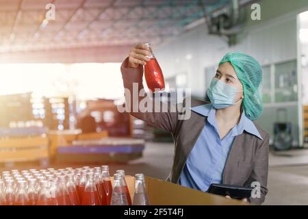 Qualitätskontrolle Inspektor Person arbeitet in der Getränkfabrik stichprobenartig zu überprüfen verunreinigen die Endprodukte. Stockfoto