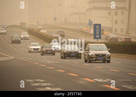 Peking, China. März 2021, 28th. Autos fahren auf einer Straße während Sandsturm in Peking, Hauptstadt von China, 28. März 2021. Quelle: Ren Chao/Xinhua/Alamy Live News Stockfoto