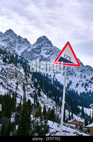 Straßenschild informiert über einen steilen Aufstieg vor dem Hintergrund von felsigen Berggipfeln mit steilen Hängen; das Konzept der Aufstieg, Erfolg, Leistung Stockfoto