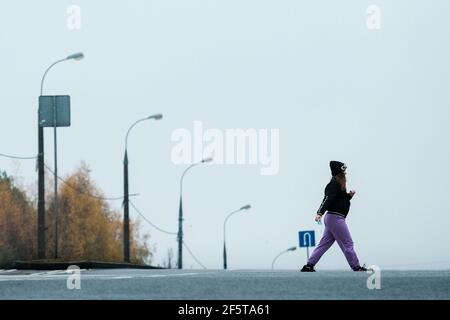 MOSKAU, RUSSLAND - 02 2020. NOVEMBER: Ein Mädchen mit einer Maske in der Hand überquert die Straße nach Jasenevo Stockfoto