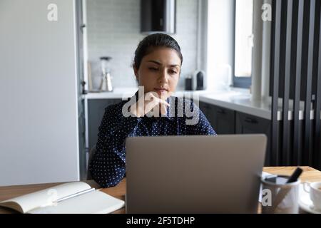 Nahaufnahme nachdenkliche indische Frau Blick auf Laptop-Bildschirm Stockfoto