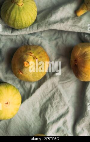 Reife süße grüne Feigen, frisch von einem heimischen Baum geerntet, auf der pastellblauen Tischdecke. Gesunde und biologische Früchte. Auch bekannt als reife weiße Feigen Stockfoto