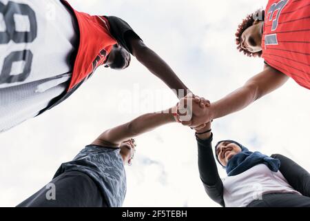 Von unten von multirassischen Team von Streetball-Spieler Stapeln Hände Zusammen vor dem Basketballspiel Stockfoto