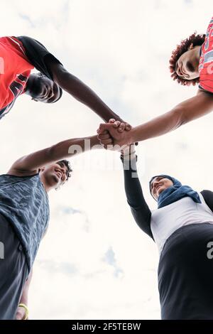 Von unten von multirassischen Team von Streetball-Spieler Stapeln Hände Zusammen vor dem Basketballspiel Stockfoto