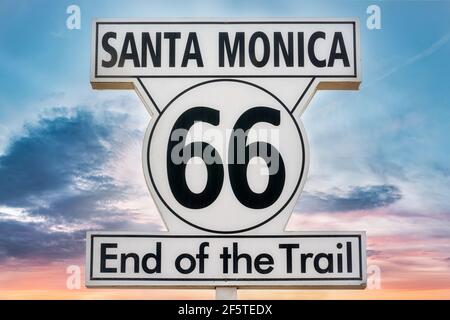 Niedriger Winkel von Schild mit Inschrift Santa Monica 66 Ende Der Trail auf dem Hintergrund der bunten Sonnenuntergang Himmel Stockfoto
