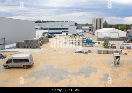 Produktionswerkstätten und Bauarbeiten. Workflow-Szene im Industriehof. Verlegung Pflasterplatten Fertiger Arbeiter. Geschäftsaufbau Stockfoto