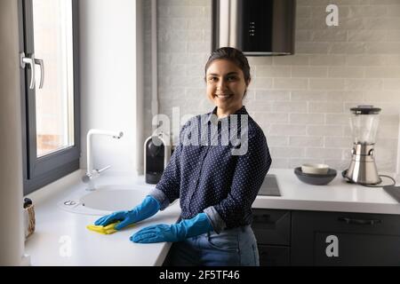 Portrait lächelnd indisch Frau hausfrau Reinigung Küche Tisch Oberfläche Stockfoto