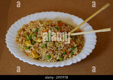 Gebratenen Reis in einer weißen Schale und asiatische Essstäbchen Stockfoto
