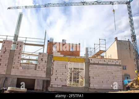 Bauprozess gegen blauen Himmel. Belüftelte Betonblöcke. Industrieller Hintergrund Stockfoto