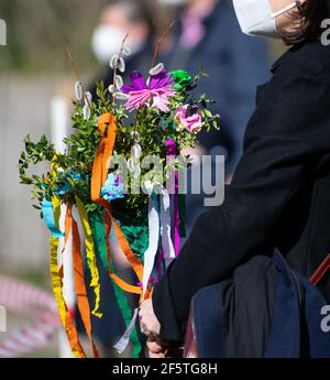 Tutzing, Deutschland. März 2021, 28th. Eine Frau hält während des Palmsonntags vor der St. Josephs Kirche einen sogenannten "Palmstrauß" in den Händen. Palmsonntag markiert den Beginn der vorösterlichen Karwoche mit Ostern als Höhepunkt des Kirchenjahres. Quelle: Sven Hoppe/dpa/Alamy Live News Stockfoto