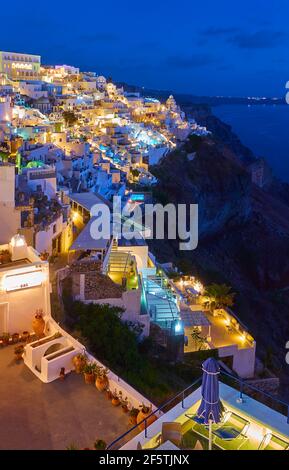 Hell erleuchtete Fira Stadt auf Santorini Insel in der Abenddämmerung, Griechenland. Nachtlandschaft Stockfoto