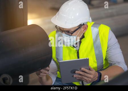 Ingenieure untersuchen neue beschichtete Rohre im Werk, Ventory Check Stockfoto