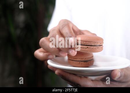 Junger Mann, der Brownie auf dem Teller isst Stockfoto