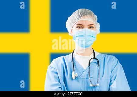 Porträt des kaukasischen Arztes mit Maske mit Flagge von Schweden im Hintergrund, COVID-19 Viruskrankheit Krise, Coronavirus globale Pandemie, SoC Stockfoto