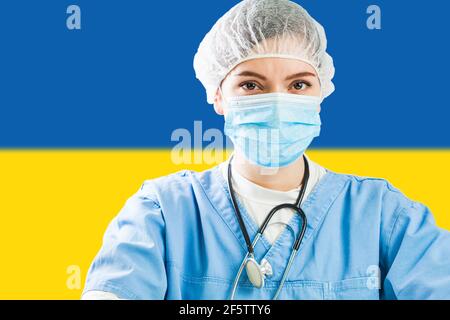 Porträt der Ärztin trägt Gesichtsmaske mit Flagge der Ukraine im Hintergrund, COVID-19 Virus-Krise, Coronavirus globale Pandemie, Stockfoto