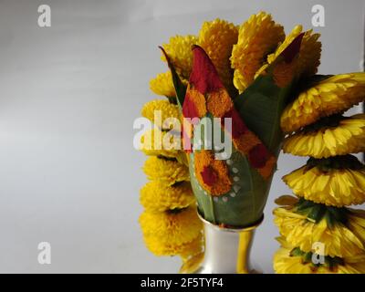 Eine silberne Kalasche mit Chrysantheme Blumen, Blätter, Kumkum, Kurkuma, ganesha, Und lakshmi isoliert auf weißem Hintergrund Stockfoto