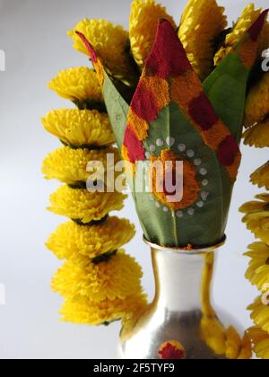 Eine silberne Kalasche mit Chrysantheme Blumen, Blätter, Kumkum, Kurkuma, ganesha, Und lakshmi isoliert auf weißem Hintergrund Stockfoto