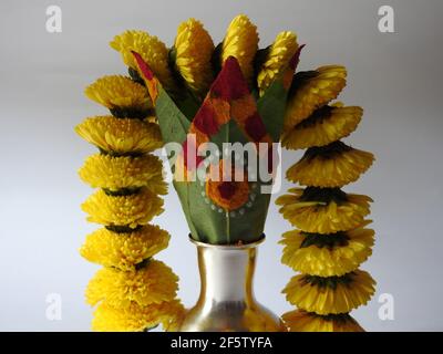 Eine silberne Kalasche mit Chrysantheme Blumen, Blätter, Kumkum, Kurkuma, ganesha, Und lakshmi isoliert auf weißem Hintergrund Stockfoto