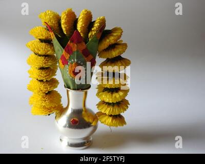 Eine silberne Kalasche mit Chrysantheme Blumen, Blätter, Kumkum, Kurkuma, ganesha, Und lakshmi isoliert auf weißem Hintergrund Stockfoto