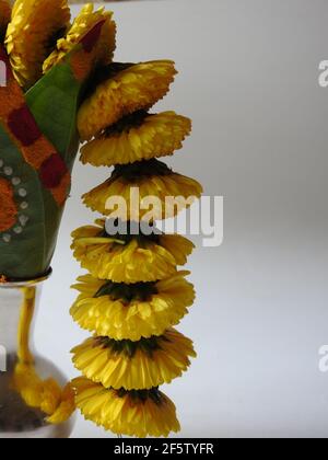 Eine silberne Kalasche mit Chrysantheme Blumen, Blätter, Kumkum, Kurkuma, ganesha, Und lakshmi isoliert auf weißem Hintergrund Stockfoto