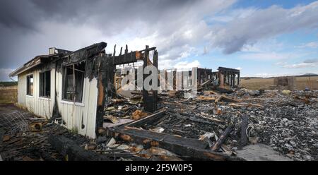 Die Überreste eines Hauses nach einem verheerenden Feuer Stockfoto