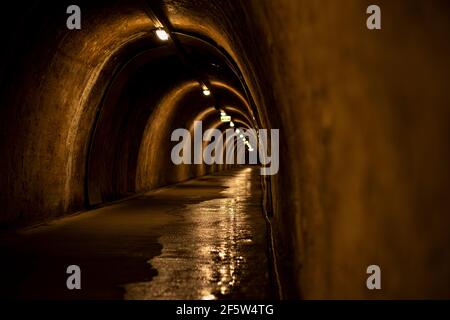 Unterirdischer Tunnel mit mehreren Ausgängen, beleuchtet durch Licht. Alter Tunnel in der Hauptstadt Kroatiens in der Stadt Zagreb.Historischer unterirdischer Tunnel und Stockfoto