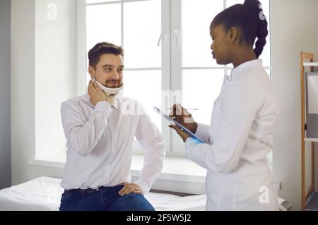 afroamerikanischer Arzt und kaukasischer Patient mit verletzten Hals sprechen Stockfoto