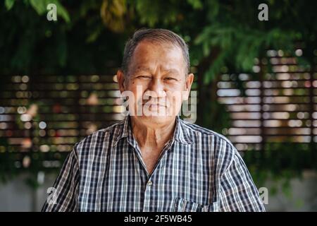 Nahaufnahme Porträt von Lächeln asiatischen Senior Mann Blick auf die Kamera. Alter thailänder Stockfoto