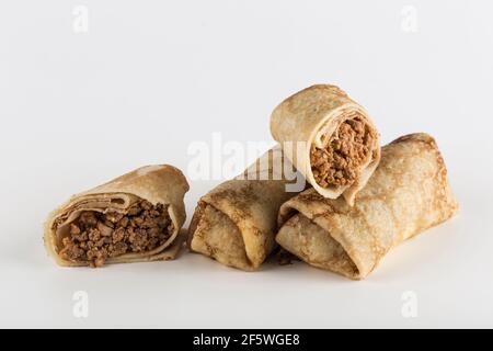 Mehrere Pfannkuchen mit Fleischfüllung auf weißem Hintergrund Nahaufnahme mit einem Kopierplatz für den Text, isoliert. Traditionelles Essen für die Maslenitsa holida Stockfoto