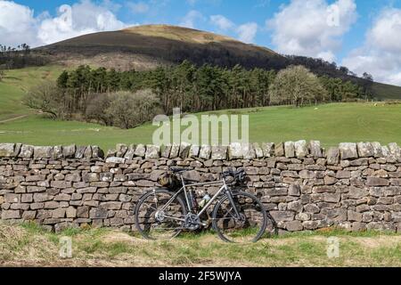 Ein Fahrrad aus Titan, das gegen eine Trockensteinmauer in Whitewell, Bowland, Lancashire, Großbritannien, geparkt ist. Stockfoto