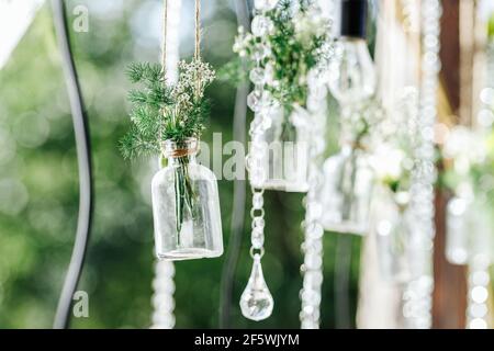 Dekorationen für die Hochzeit im Freien in Form von Mini Vasen und Blumensträuße Stockfoto