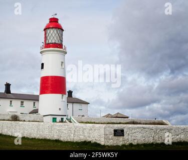 Der rot-weiß gestreifte Souter Lighthouse war der weltweit erste Leuchtturm, der mit Strom versorgt wurde. Stolz über der Nordsee stehen n Stockfoto