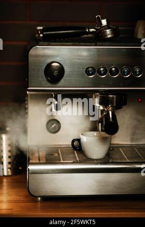 Weiße Tasse auf der Abtropfschale mit Dampf aus Der Dampfgarer Stockfoto