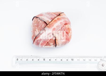 Chicken Hamburger mit Speck Nahaufnahme, ein Lineal für die genaue Größe des Kalibers auf weißem Hintergrund. Roher Hähnchen-Hamburger mit Platz für Text. Stockfoto