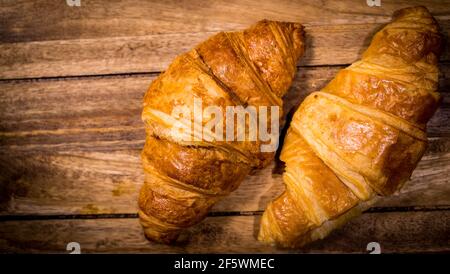 Frisch gebackene französische Croissants auf einem Holztisch Stockfoto