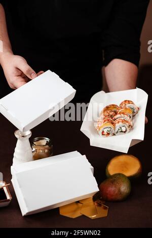 Sushi-Konzept zum Mitnehmen, Shrimps und Mango-Sushi in einer weißen Kartonschachtel Stockfoto