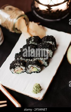 Wunderbar serviertes Sushi auf einem weißen Tonteller Stockfoto