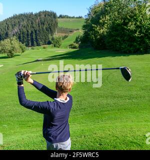 Junior Golfspieler schlagen Kugel Stockfoto