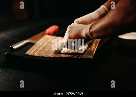 Nahaufnahme des Zubereitungsvorgangs von rollendem Sushi. Stockfoto